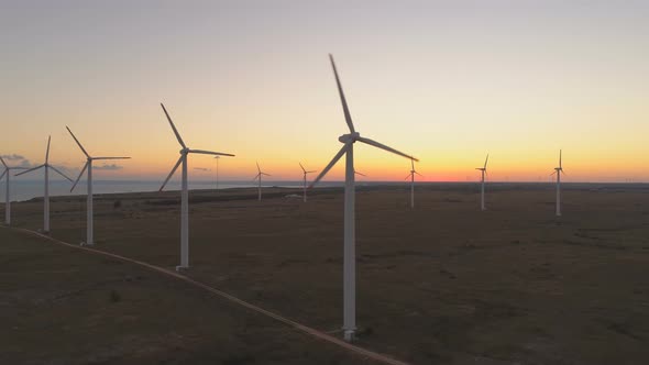 Wind Turbines at Wind Farm Generating Renewable Energy at Sunset alt