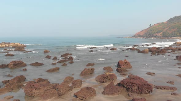 Fly over small beach rocks, serene and quiet Arambol beach, Goa, India.   alt