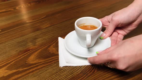 A Napkin is Laid Out on the Table Espresso and a Glass of Water are Placed