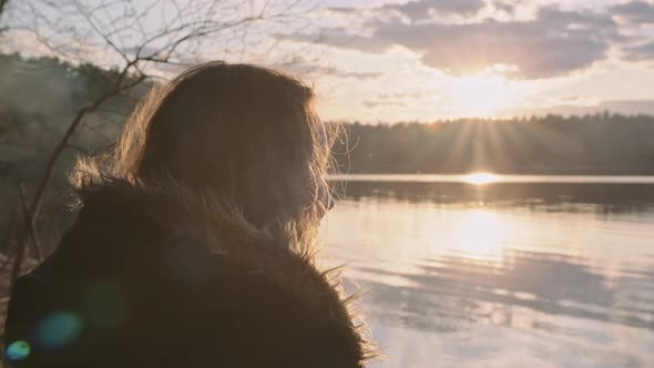 A Young Plump Beautiful Girl at Sunset By the Lake in the Rays of the Sun alt
