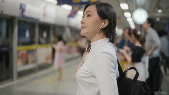 Portrait of asian woman with earphone listening music and using smartphone