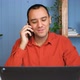 Smiling Young Business Man Professional Talking on Phone Using Laptop Sit at Home Office Desk - VideoHive Item for Sale