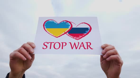 Man Hands Holding of Heart Drawingon the Cardboard with Words Stop War alt