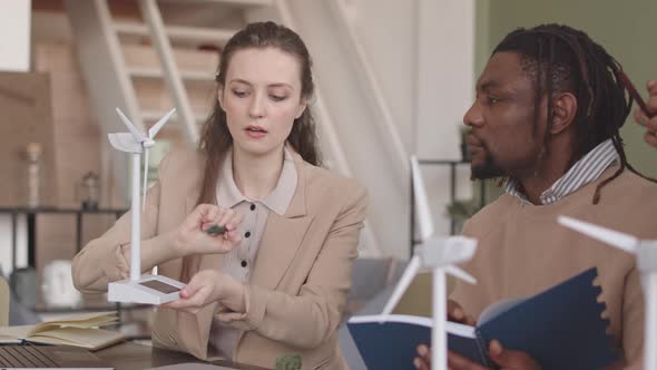 Multiethnic Engineers Discussing Project of Renewable Energy alt