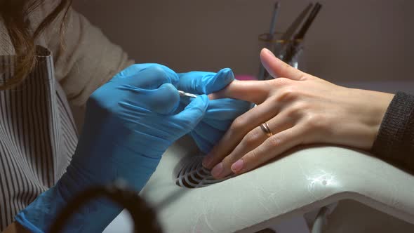 Close up footage of professional nail file drill in action finger nail treatment	 alt