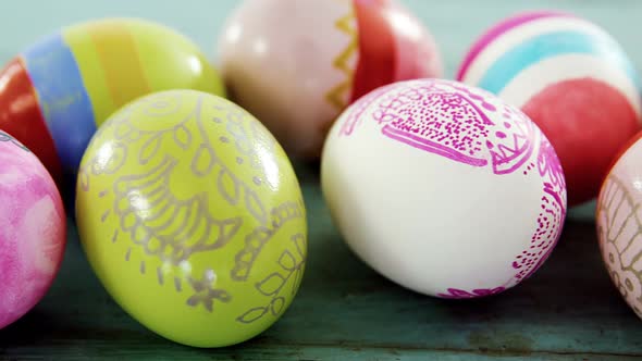 Painted Easter eggs on wooden surface alt