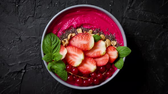 Summer Berry Smoothie or Yogurt Bowl with Strawberries Red Currants and Chia Seeds on Black
