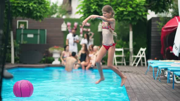 Wide Shot of Happy Joyful Girl Jumping Diving in Swimming Pool with Water Splashing in Slow Motion alt