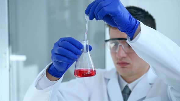 Scientist Dropping Red Liquid