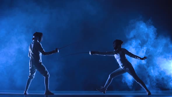 Two Female Athletes Train on Foil at Fencing Tournament alt