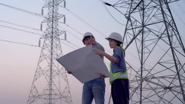 Two specialist electrical engineer working near to High voltage tower.