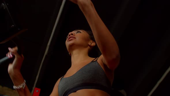 Low Angle View of Pretty Sporty Fit African Female Working Out on Exercise Bike alt