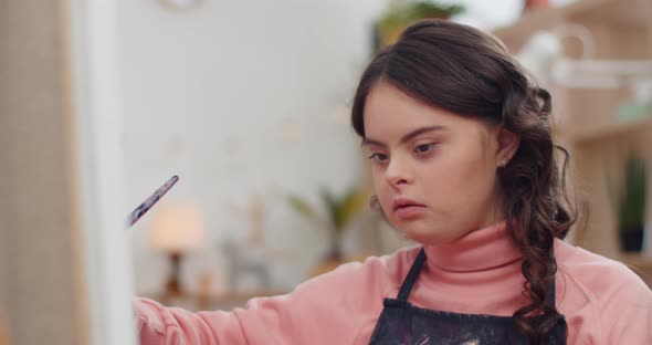 Close Up View of Talanted Teen in Aprone with Down Syndrome Creating Picture in Her room, Beautiful alt