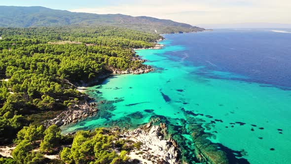 Aerial drone view of the Aegean sea rocky coast with blue transparent water alt