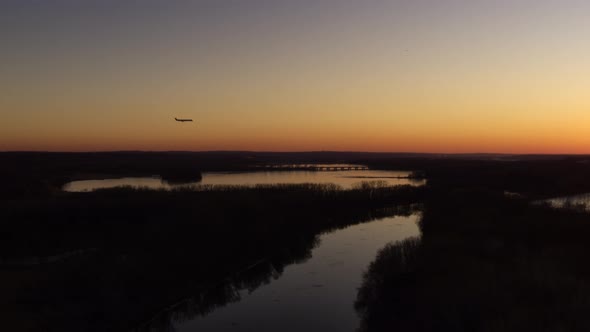 Silhouetted against the evening sky, a plane comes in to land at Saint Paul International Airport. alt