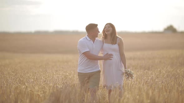 Beautiful Couple with Pregnant Woman in Forest.