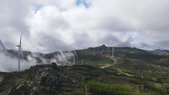 Eolic turbines in absence of wind on cloudy day at Caramulo in Portugal. Aerial forward alt