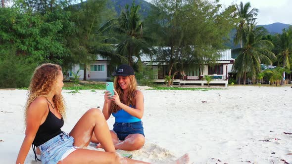 Ladies relaxing on marine tourist beach journey by blue lagoon with white sandy background of Koh Ph alt