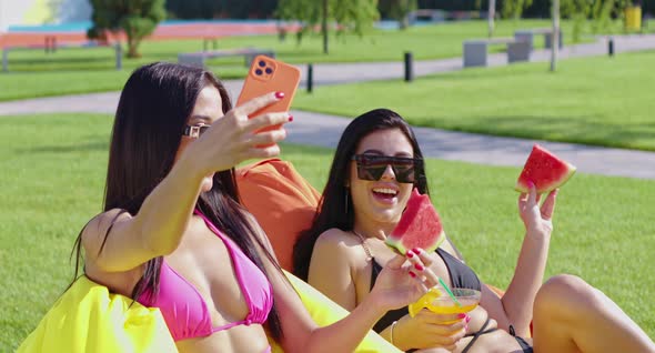 Happy Women in Swimsuits Taking Selfie on Cell Phone alt