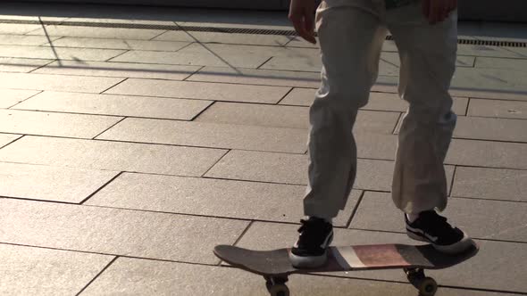 Feet of Man Skater Making Ollie Trick From Bank alt