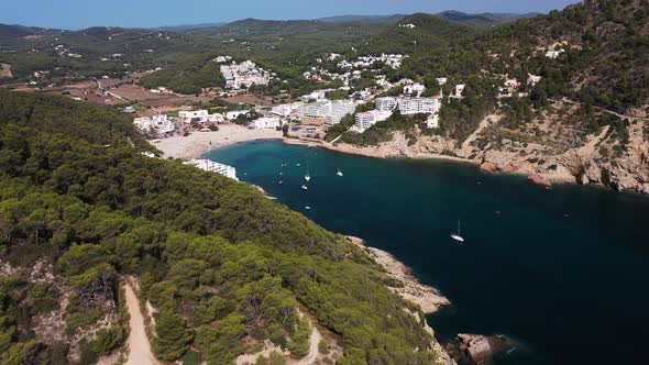 Aerial footage of the Spanish island of Ibiza showing the beautiful beach front alt