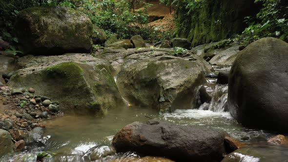 Flying above a stream in the tropics showing the water flowing alt