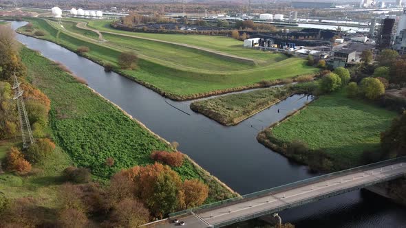 Descending aerial shot of, river and walking path beside chemical area alt