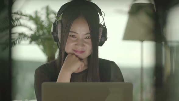 Young Asian Woman Watching Music Video on Computer at Home alt