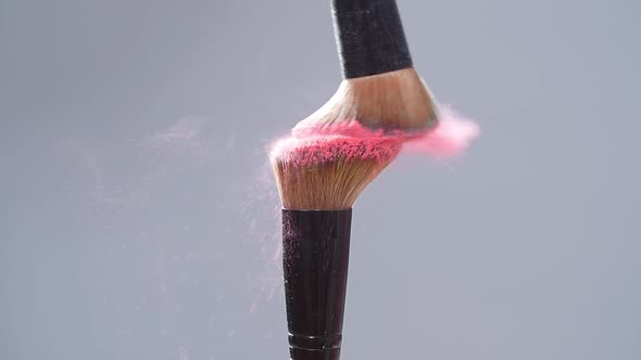 Make-up Brush with Pink Powder Splashes Explosion on Gray Background on Slow Motion alt