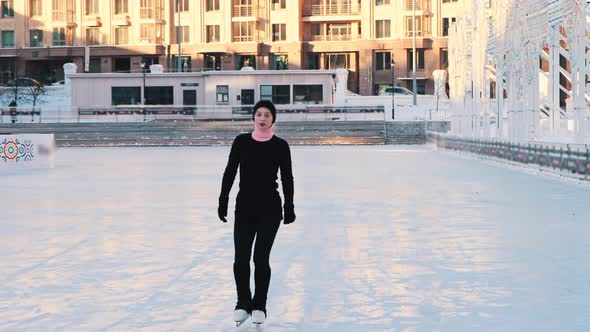 Young Beautiful Woman Skating on Public Ice Rink  Looking in the Camera alt