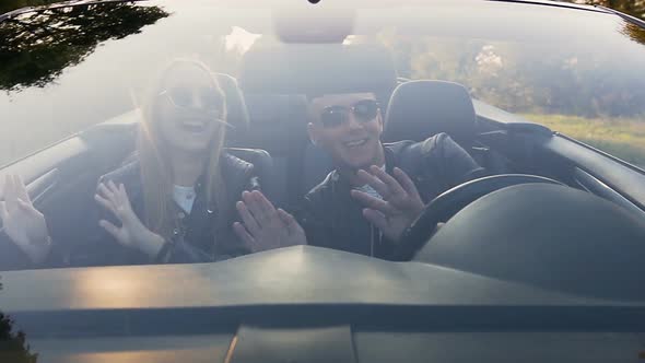 Happy Young Couple Dancing in Cabriolet alt