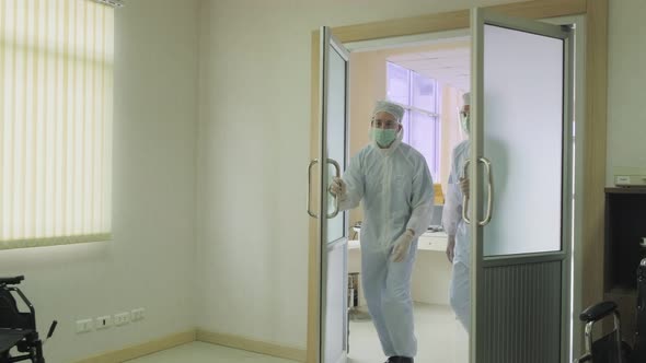 Emergency paramedic doctors with PPE suit open door coming to cure severe condition covid patient. alt