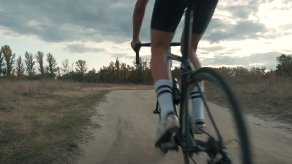 Cycling Athlete Cycling On Trail. Cyclist Twists Pedals And Riding On Gravel Bike. alt