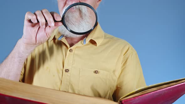 Old Man Looking At Book With Magnifying Glass 2