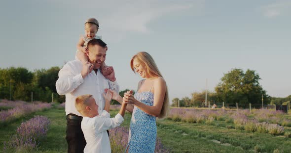 Portrait of a Happy Family in a Lavender Field Their House in the Distance alt