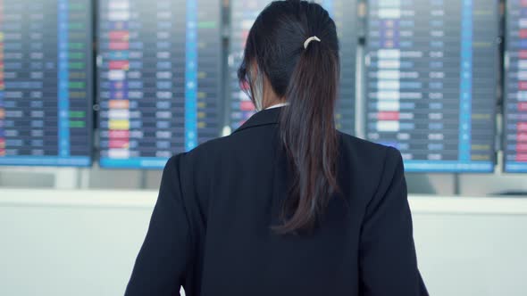 Asian business girl wear face mask with suitcase stand in front of board look at information check.