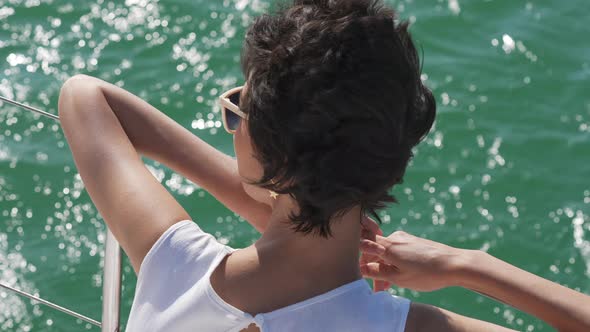 4K Portrait of Caucasian woman enjoy travel catamaran boat sailing in the sea at summer sunset. alt