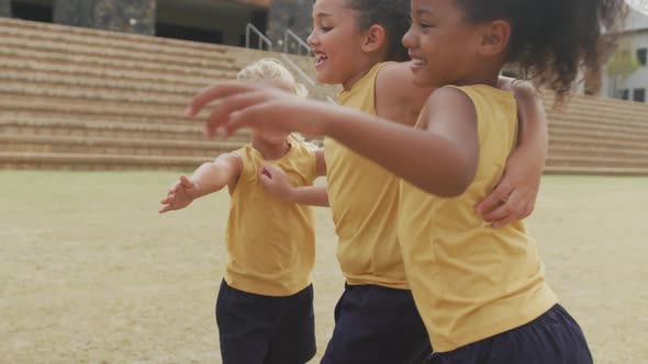 Video of legs of diverse girls hugging after soccer match in front of school alt