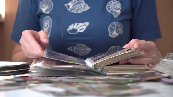 Women's Hands Flipping Through Pages of Old Photo Album