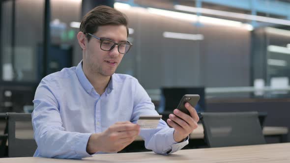 Young Man Making Unsuccessful Online Payment on Smartphone alt