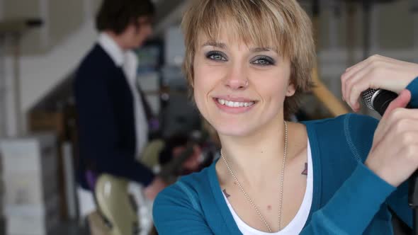 Closeup of man playing bass guitar in garage band alt