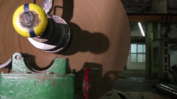 A Production Crane Lifts a Large Roll of Manufactured Paper