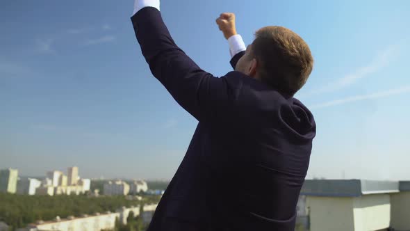 Happy Man in Suit Raising Hands Up Showing Success Gesture, Work Achievement