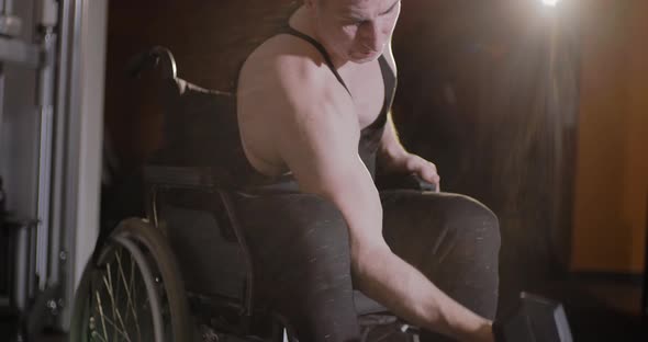 Wheelchair user doing strength exercises with dumbbells.