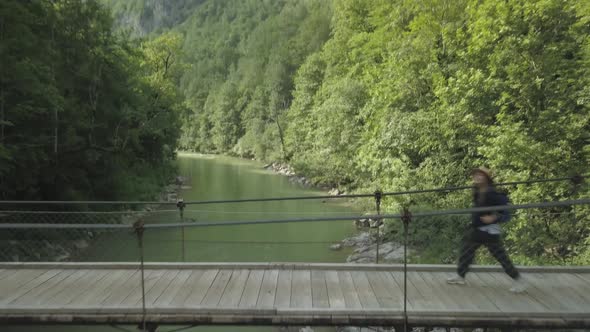 Aerial view of woman traveler walking on the bridge under Tara river in Montenegro alt