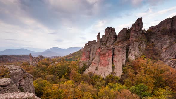 Moving clouds at autumn picturesque rock formation alt