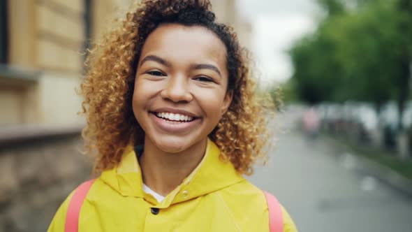 Close-up Slow Motion Portrait of Good-looking African American Woman Looking at Camera with Glad alt