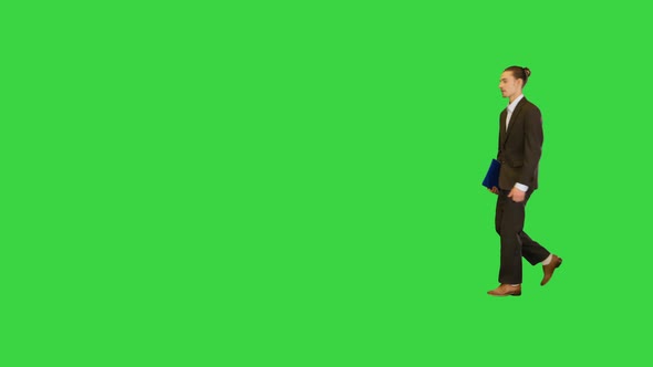 Young Office Manager Walks with Documents in His Hand on a Green Screen Chroma Key
