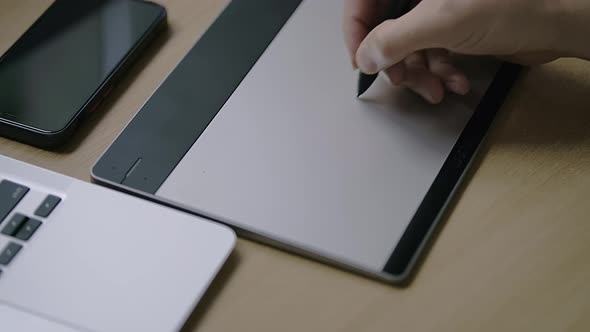 Male Caucasian Hand is Drawing a Sketch on a Graphic Tablet