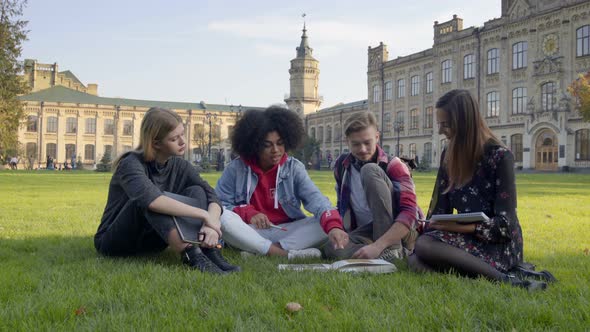 Students Sitting on the Grass  at the University or College Campus